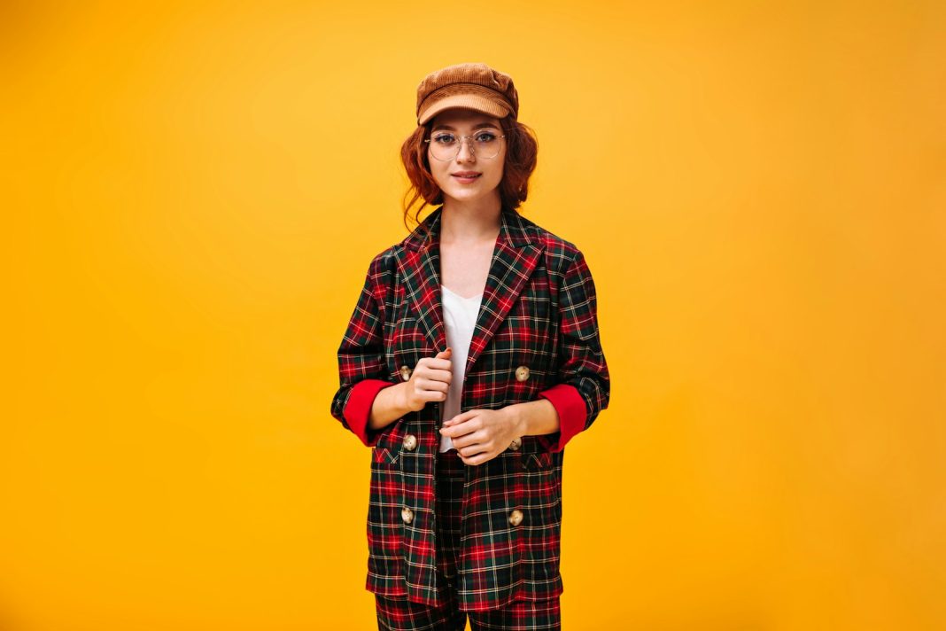 a woman in a red and black checkered coat and hat